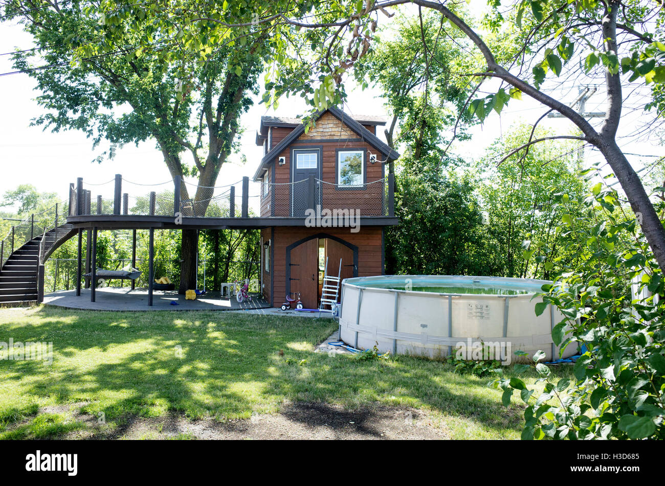 Fanciful two story tree house with a long curved stairway beside a