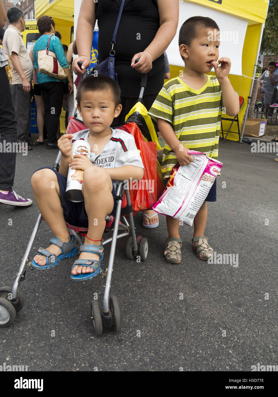 Autumn Moon Festival and Lantern Parade in Chinatown in Sunset Park in Brooklyn, NY, 2016. Young boys eating snacks. Stock Photo