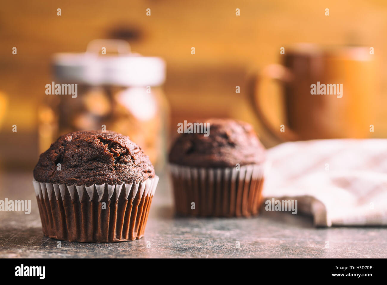 The tasty chocolate muffins on old kitchen table. Stock Photo