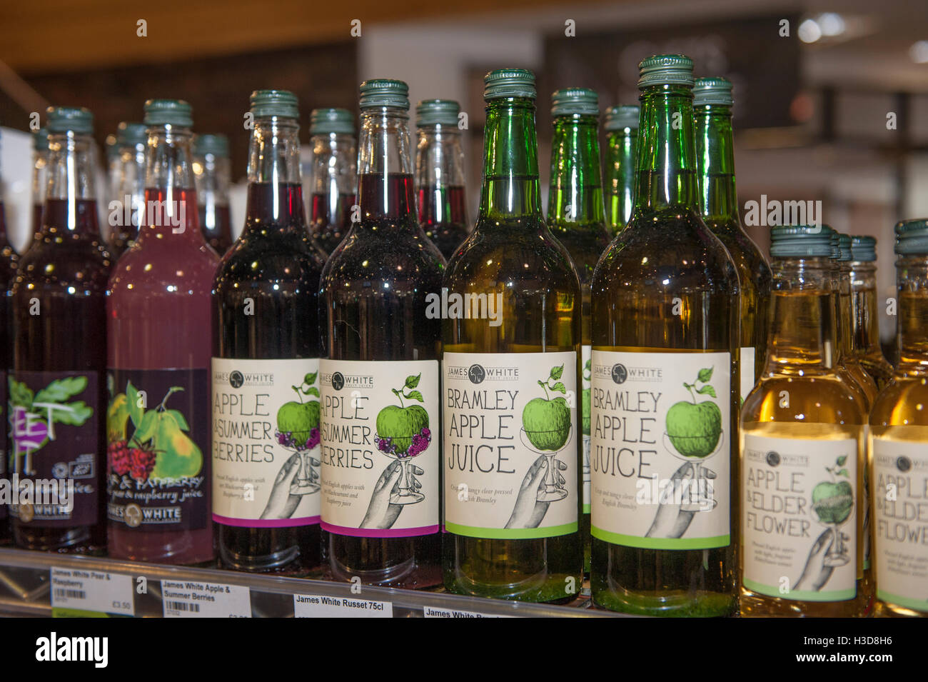 A row of bottles of fruit juice on a shelf in a food store Stock Photo
