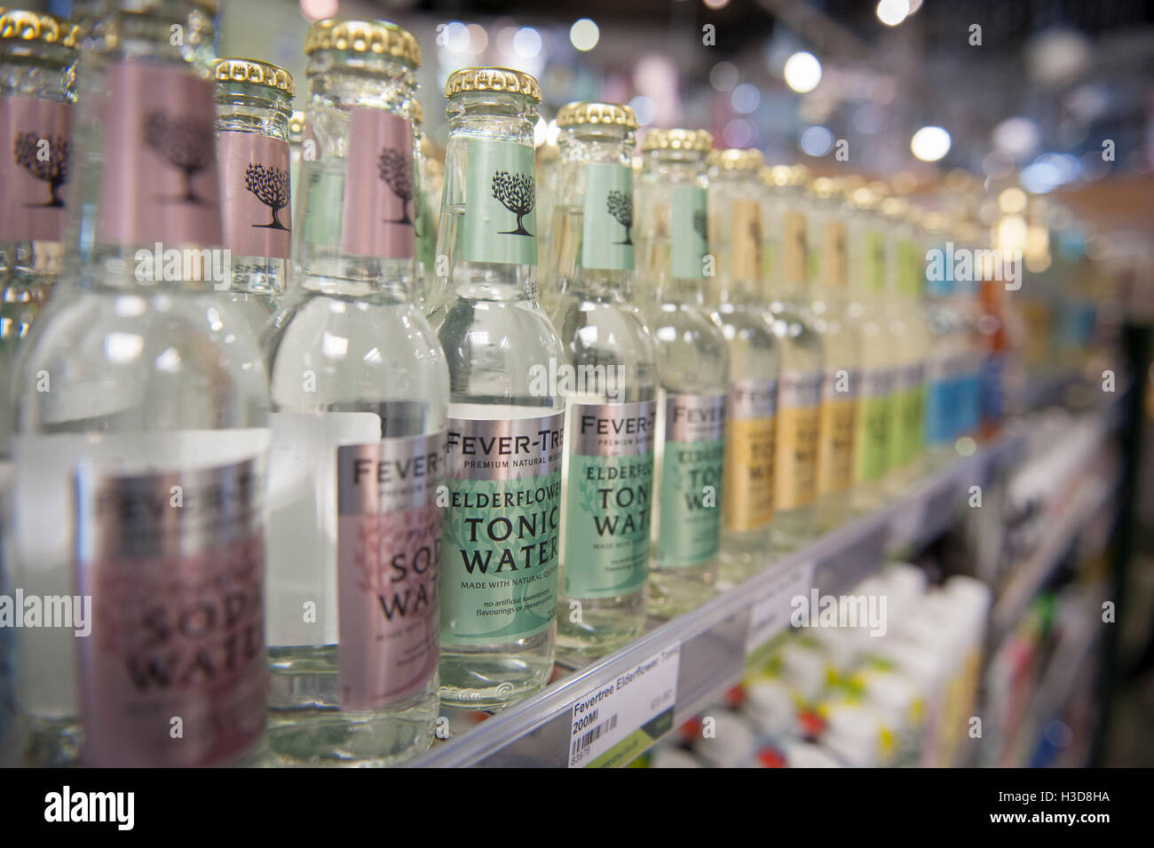 A row of tonic water bottles on a shelf in a grocery store Stock Photo