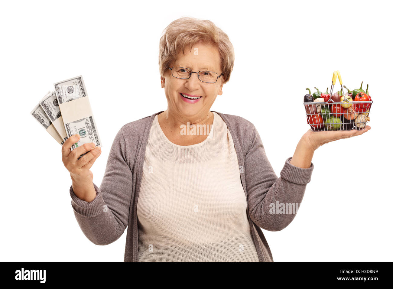 Happy elderly woman holding a small shopping basket full of fruits and ...