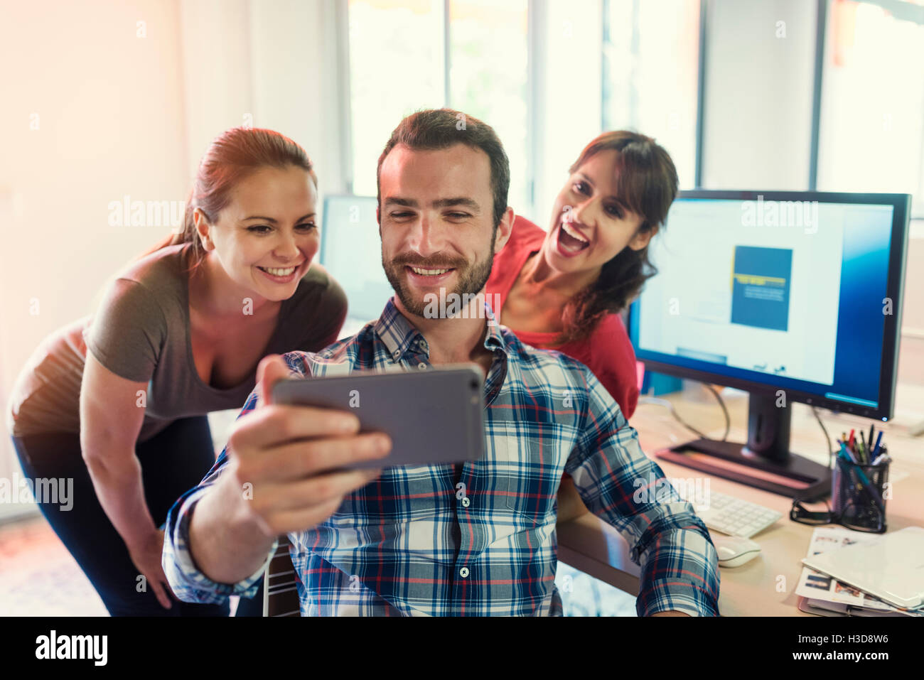 Business casual creative team taking Selfie in modern office Stock