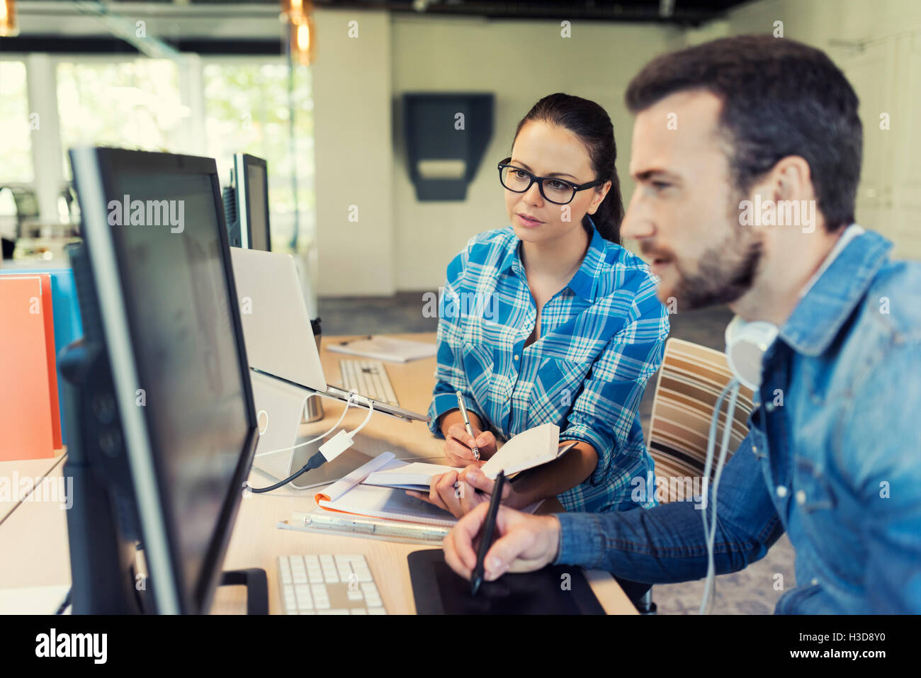 Two designers working together in graphic studio. Business team meeting in modern office Stock Photo