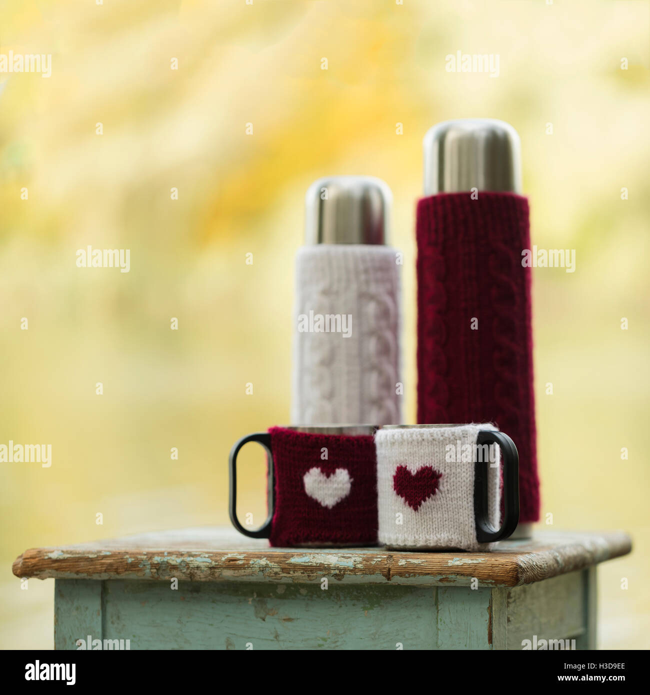 https://c8.alamy.com/comp/H3D9EE/rustic-style-on-the-old-stool-is-a-thermos-with-cups-in-knitted-covers-H3D9EE.jpg
