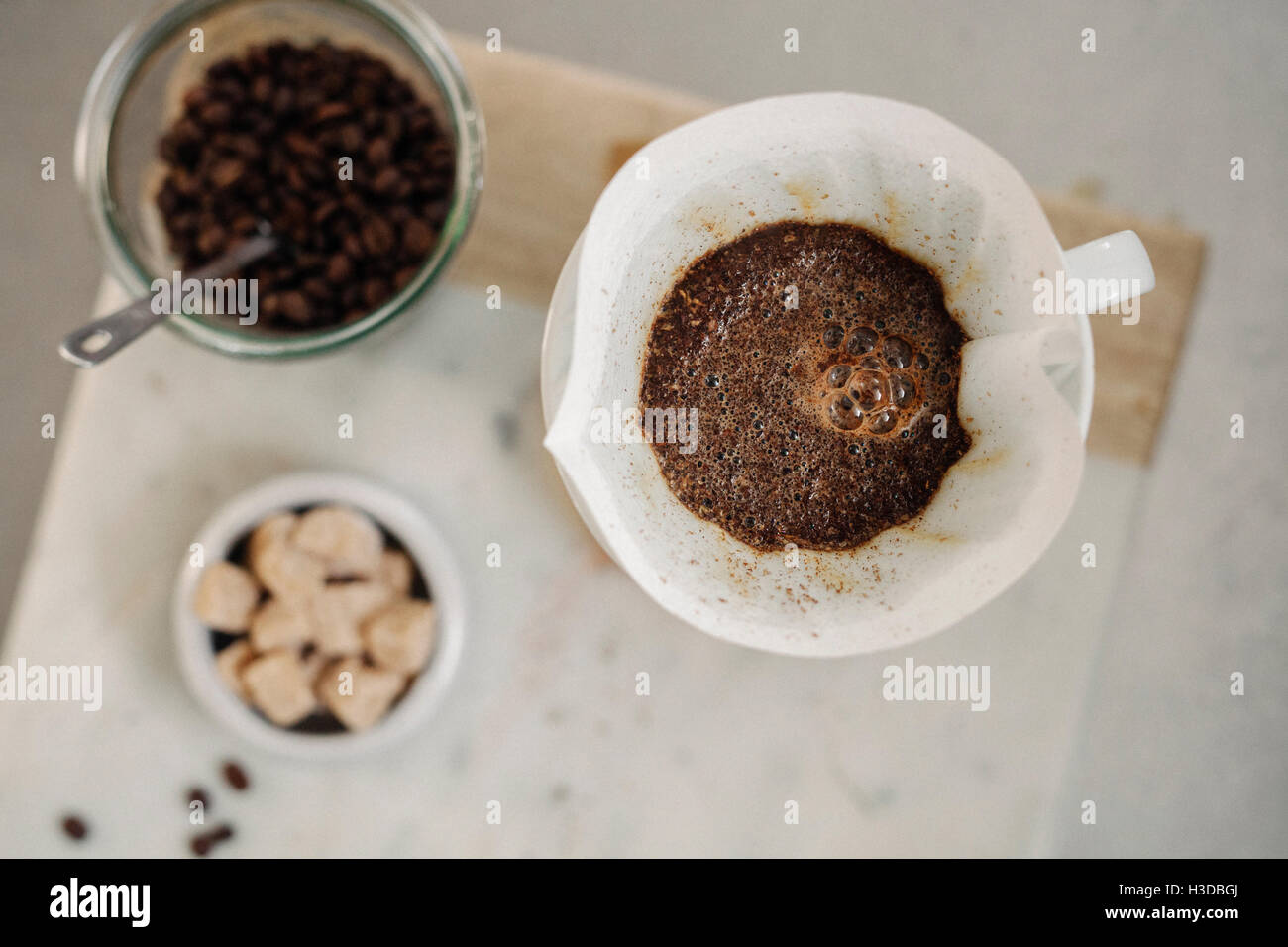 Making filter coffee. Overhead view of ground coffee, paper filter and