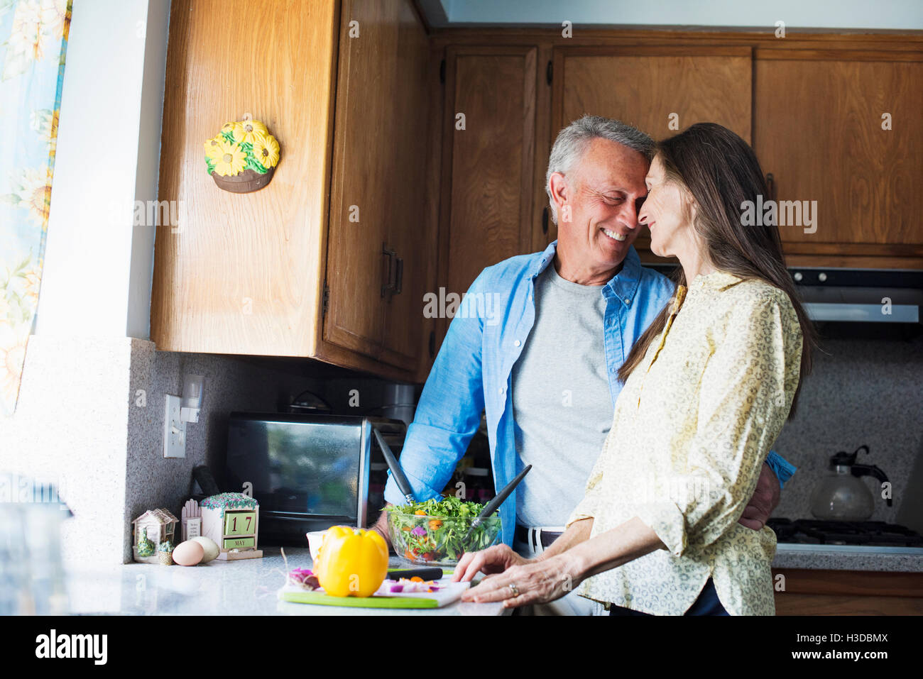 Smiling senior couple standing in a kitchen, preparing food. Stock Photo