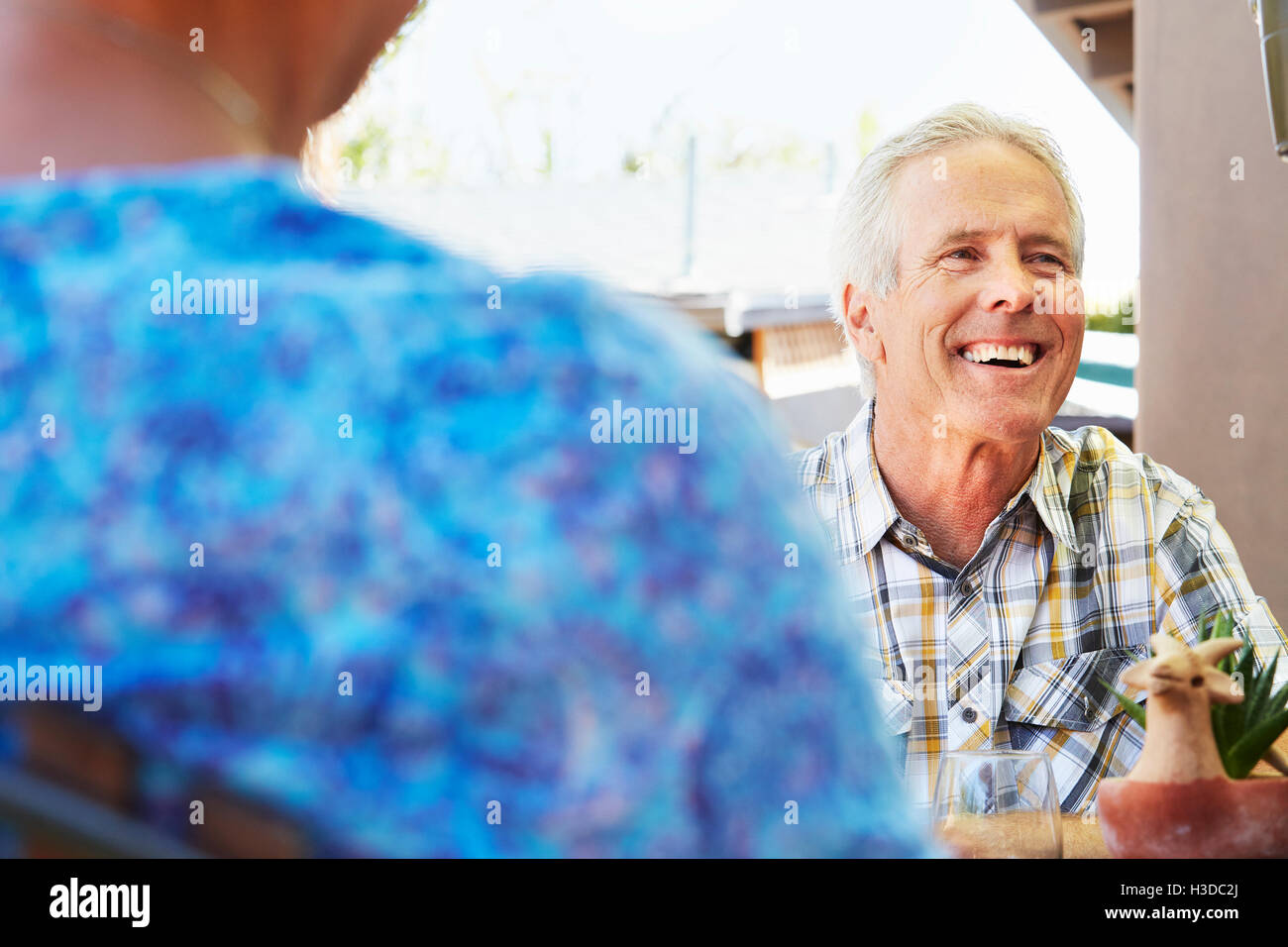 Smiling senior man with grey hair sitting outdoors. Stock Photo