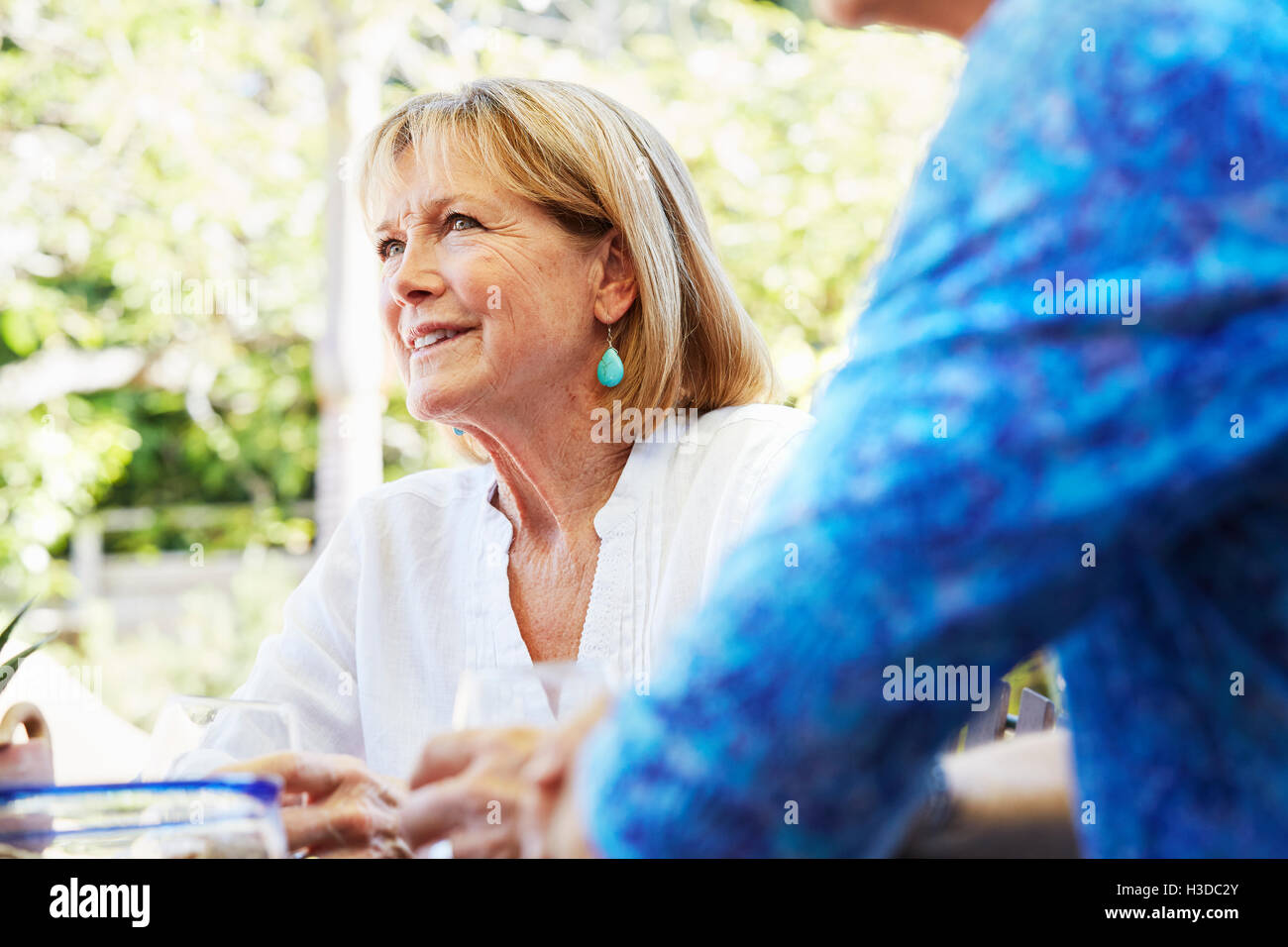 An attractive mature woman smiling and looking up at a companion. Stock Photo