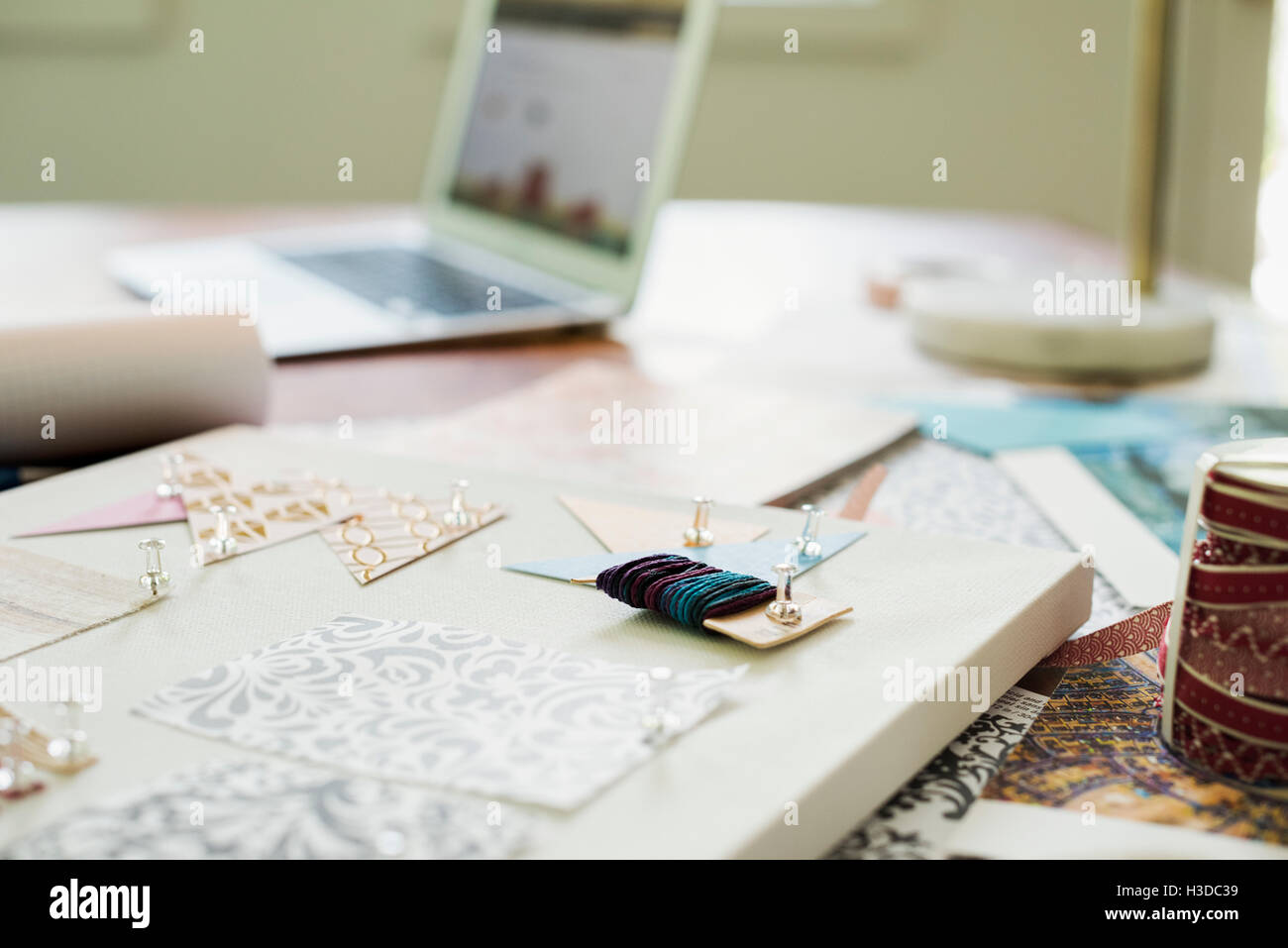 Craft materials, fabric and paper, patterns and a notebook and tablet. Stock Photo