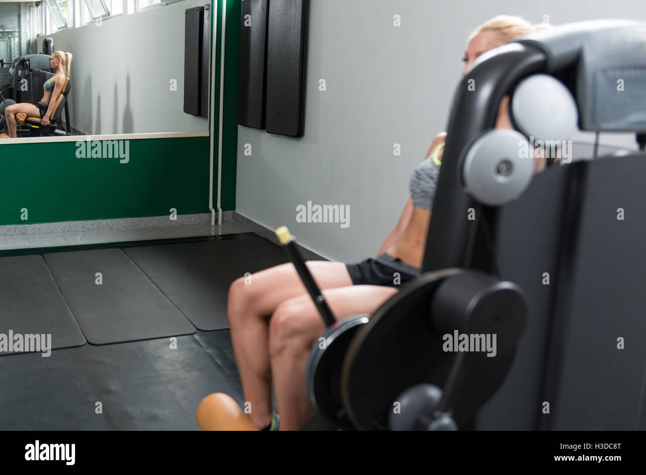 Fitness Woman Working Out Legs On Machine In A Fitness Center