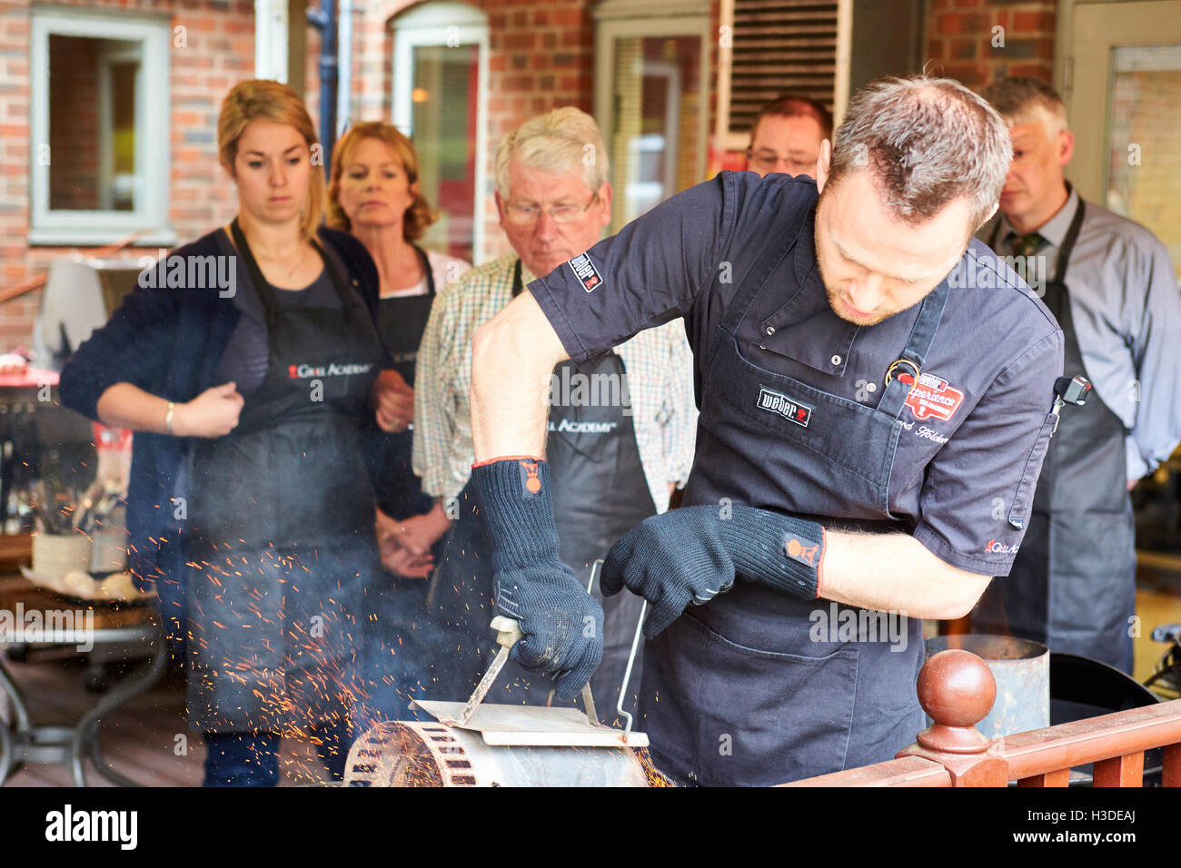 BBQ chef lighting a charcoal barbecue using a chimney starter Stock