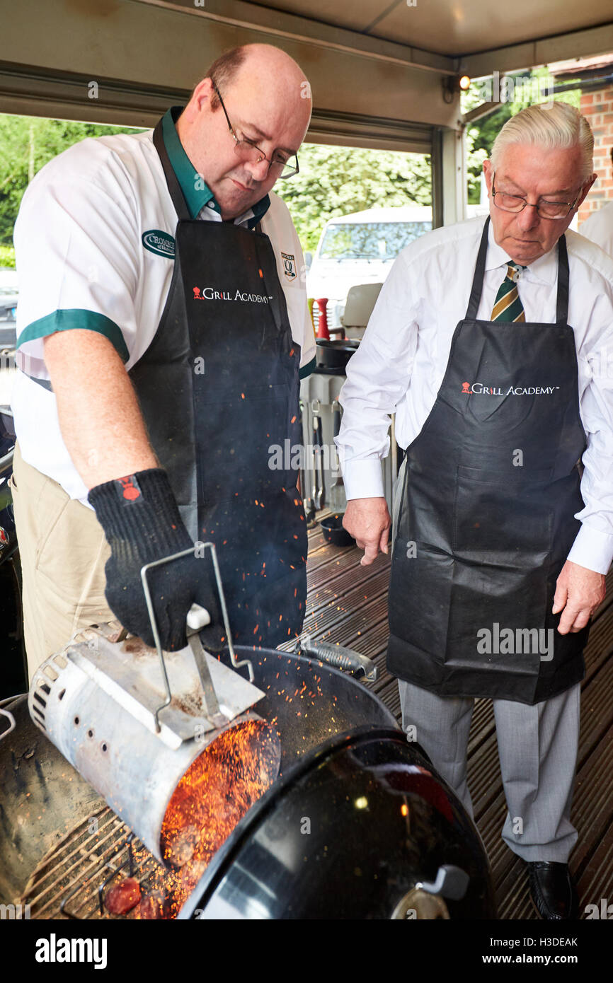 BBQ chef lighting a charcoal barbecue using a chimney starter Stock
