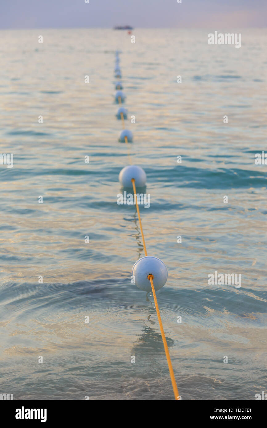 Buoys outlining a swimming area on a Caribbean beach. Focus on first