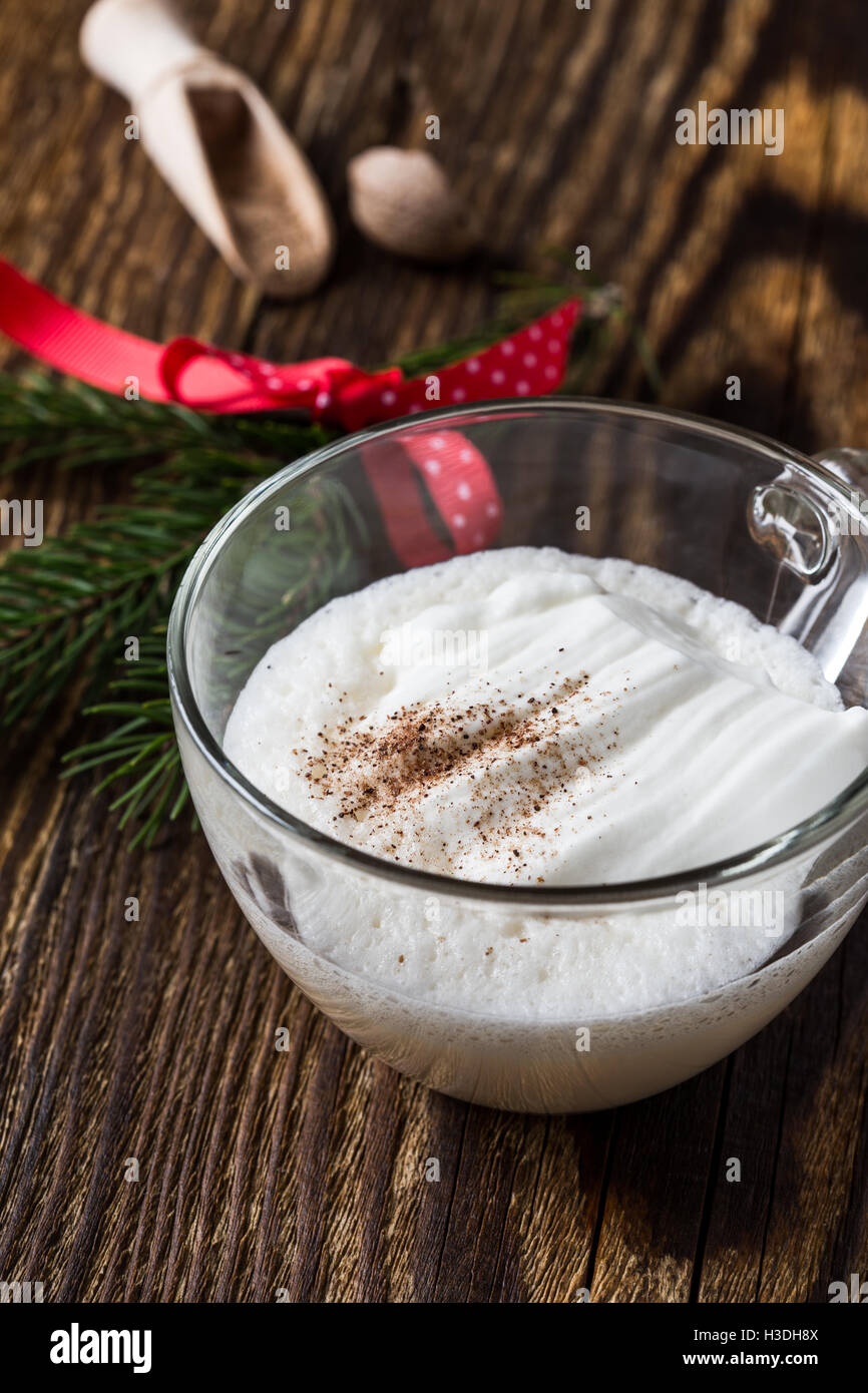 Homemade eggnog with whipped cream in glasses on wooden rustic table ...