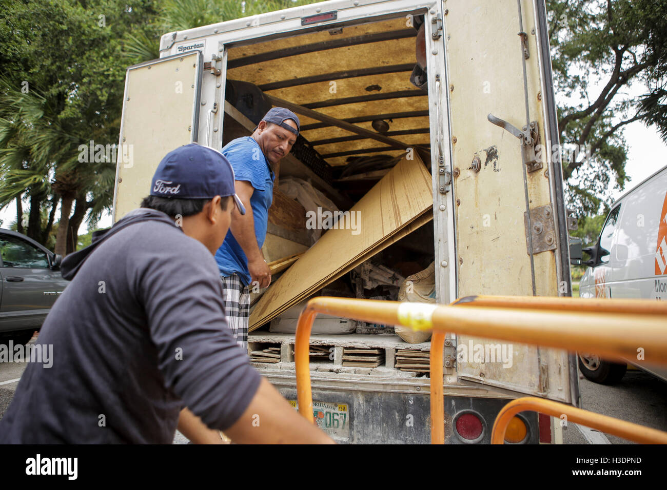 Lindo Santis, left, and Jose Alfaro, right, of Pompano Beach load