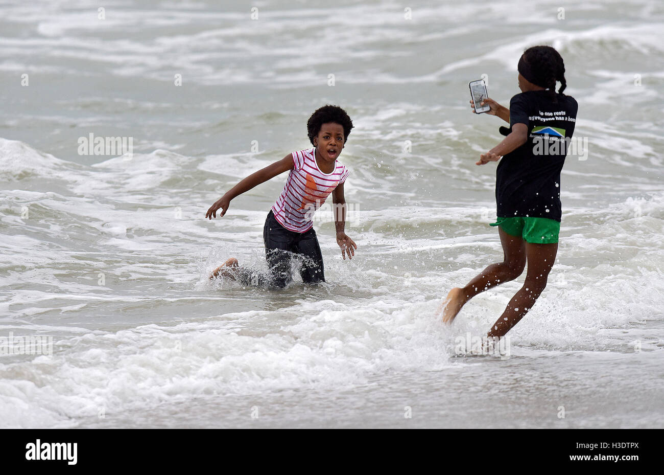 Hollywood, FL, USA. 6th Oct, 2016. Lexie Floyd, 9, left, and Destiny Desrivieres, 13, from Hollywood, take selfies while trying to avoid a large upcoming wave created by Hurricane Matthew on Dania Beach during, Thursday, October 6, 2016.SOUTH FLORIDA OUT; NO MAGS; NO SALES; NO INTERNET; NO TV. Credit:  Sun-Sentinel/ZUMA Wire/Alamy Live News Stock Photo