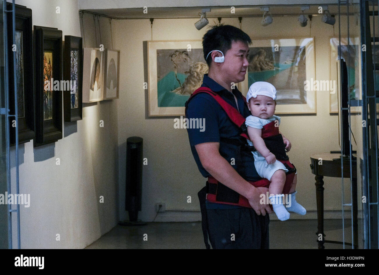 Los Angeles, California, USA. 10th Sep, 2016. A man carries a baby visits a gallery at the M50 Art Colony in Shanghai, China. Shanghai is the most populous city in China and the most populous city proper in the world. It is one of the four direct-controlled municipalities of China, with a population of more than 24 million as of 2014. It is a global financial centre, and a transport hub with the world's busiest container port. Located in the Yangtze River Delta in East China, Shanghai sits on the south edge of the mouth of the Yangtze in the middle portion of the Chinese coast. The munic Stock Photo