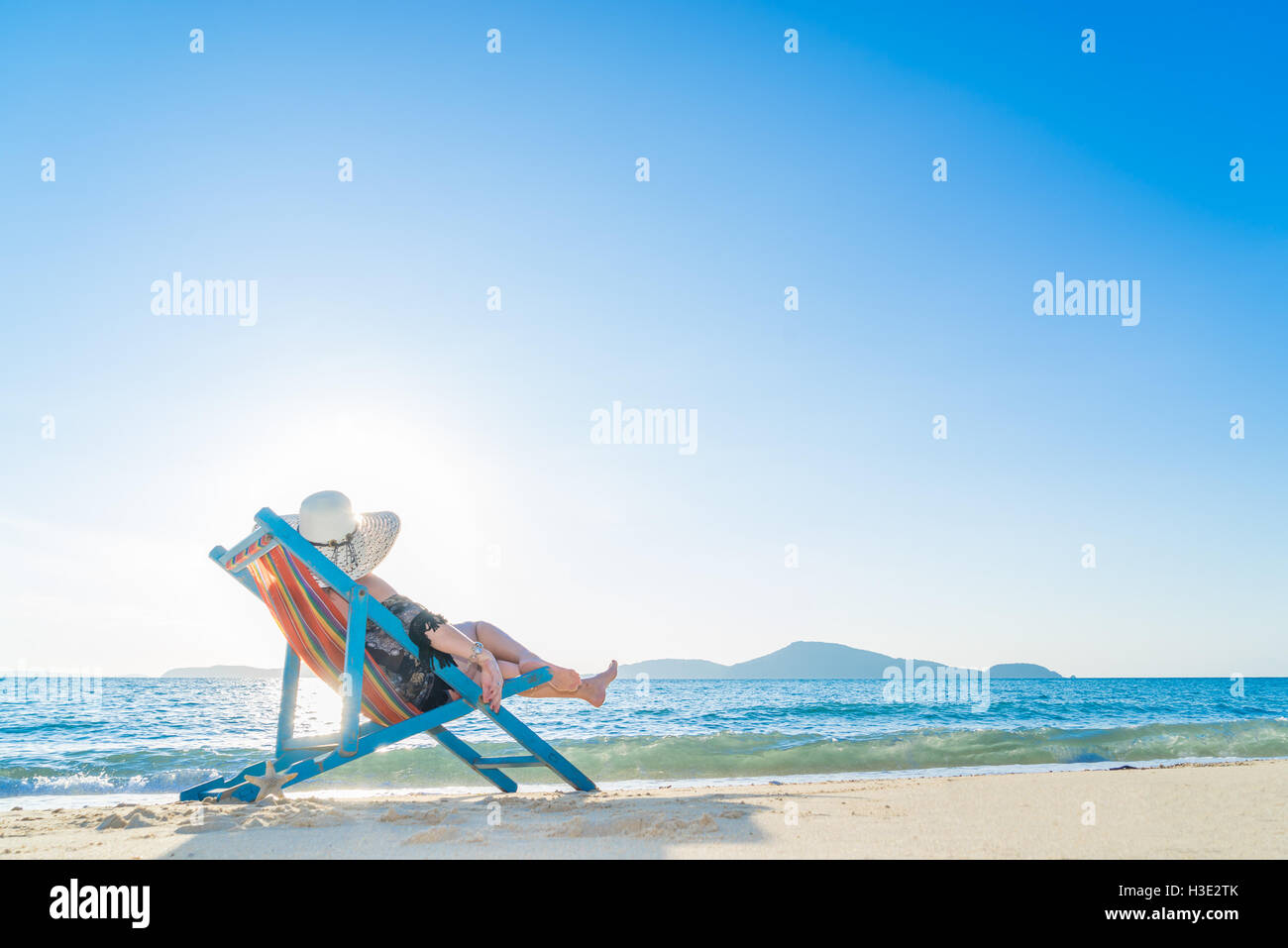 Girl on a tropical beach with a straw hat Stock Photo Alamy