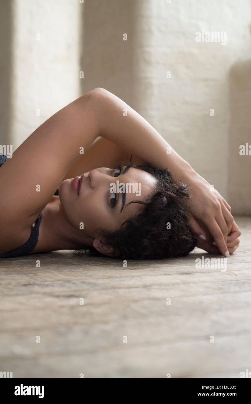 Beautiful young woman laying down on the floor Stock Photo