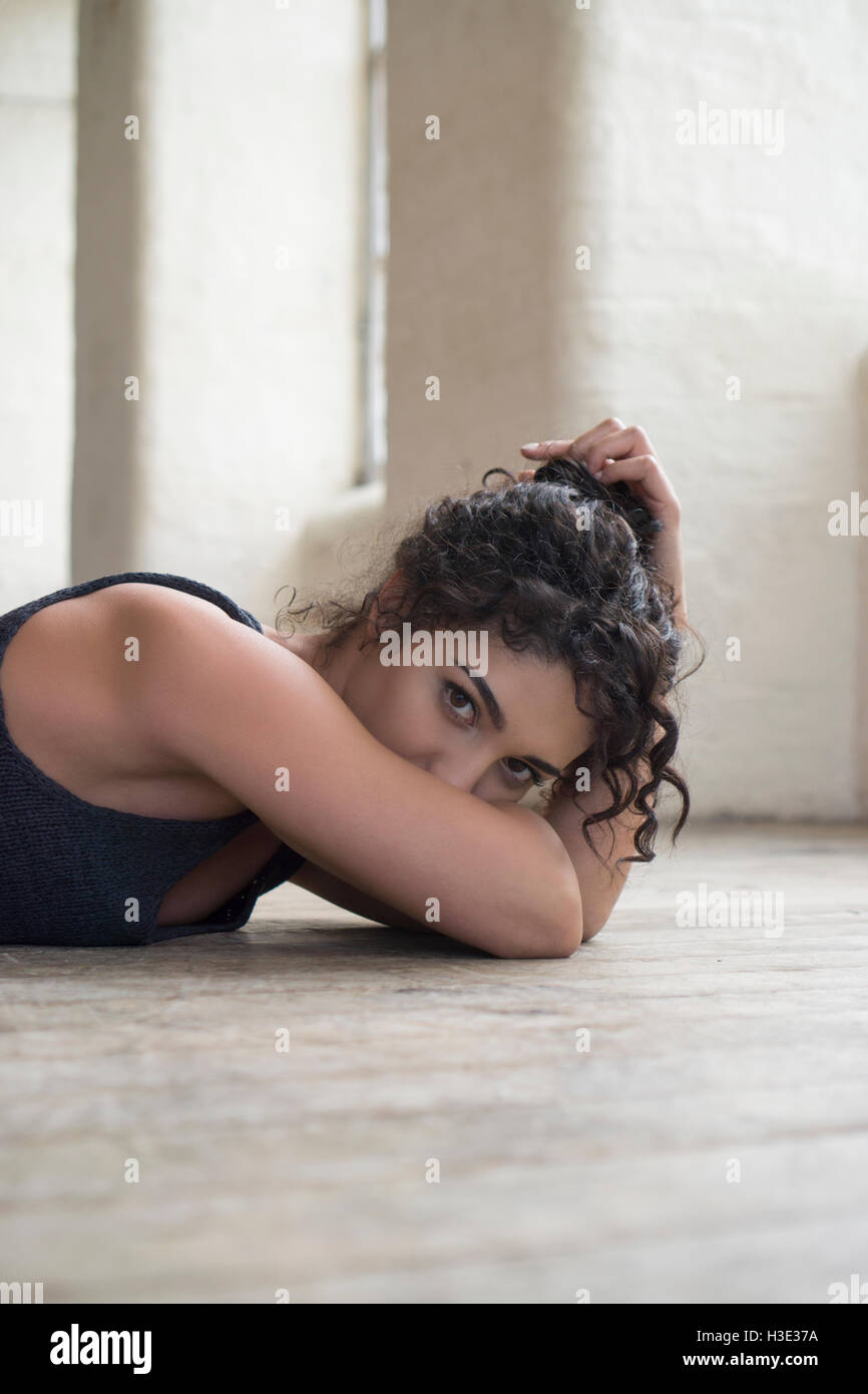 Beautiful young woman laying down on the floor Stock Photo