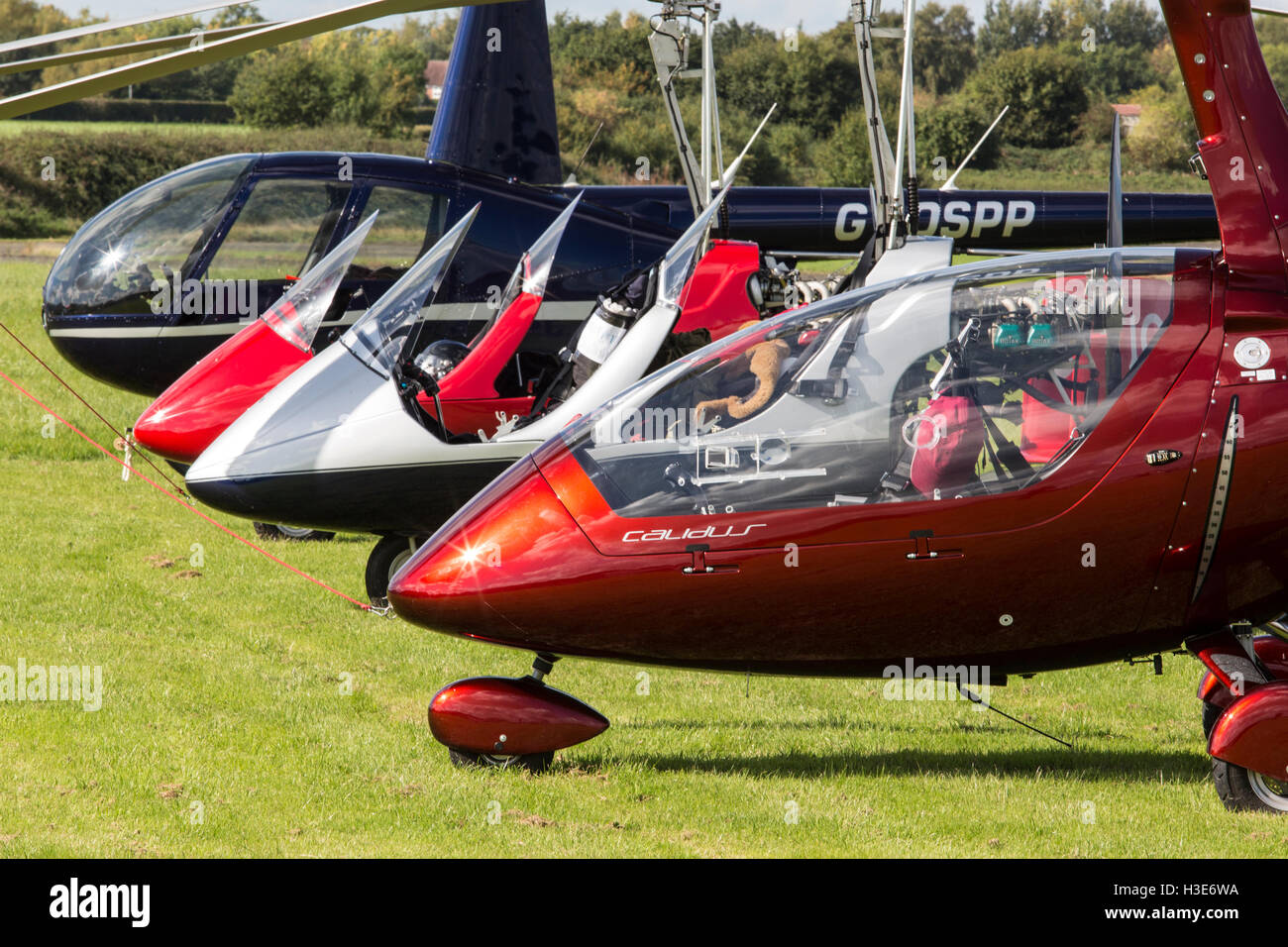Autogyro aircraft and a Robinson R-44 helicopter parked together. Stock Photo