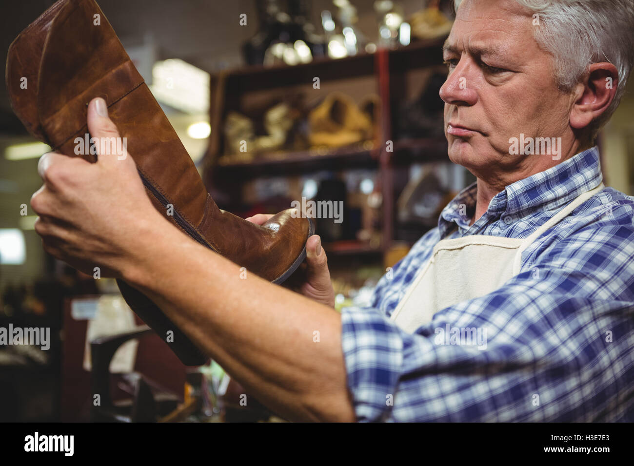Shoemaker examining a shoe Stock Photo