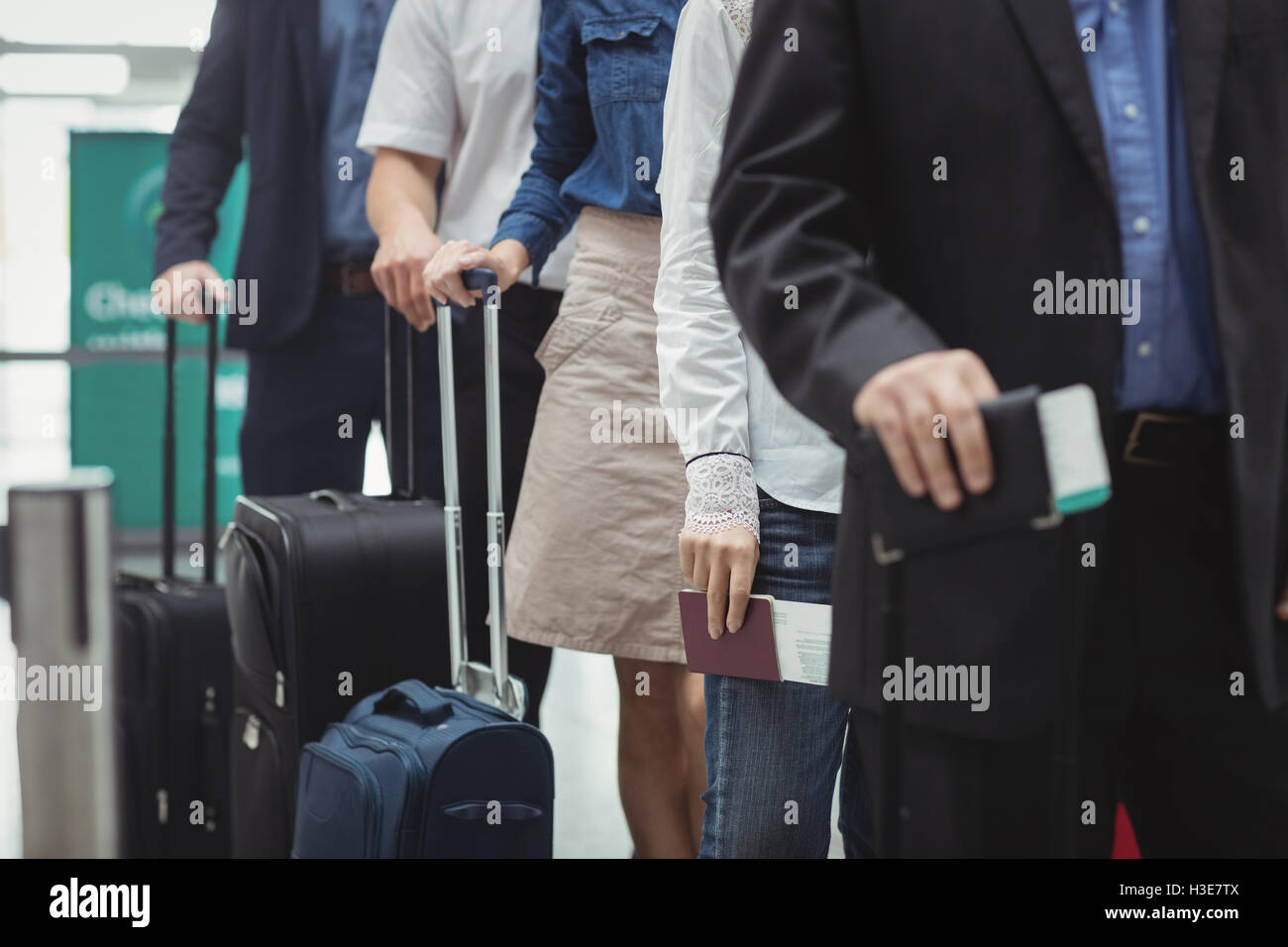 Passengers holding passports and boarding pass waiting in queue Stock Photo Alamy