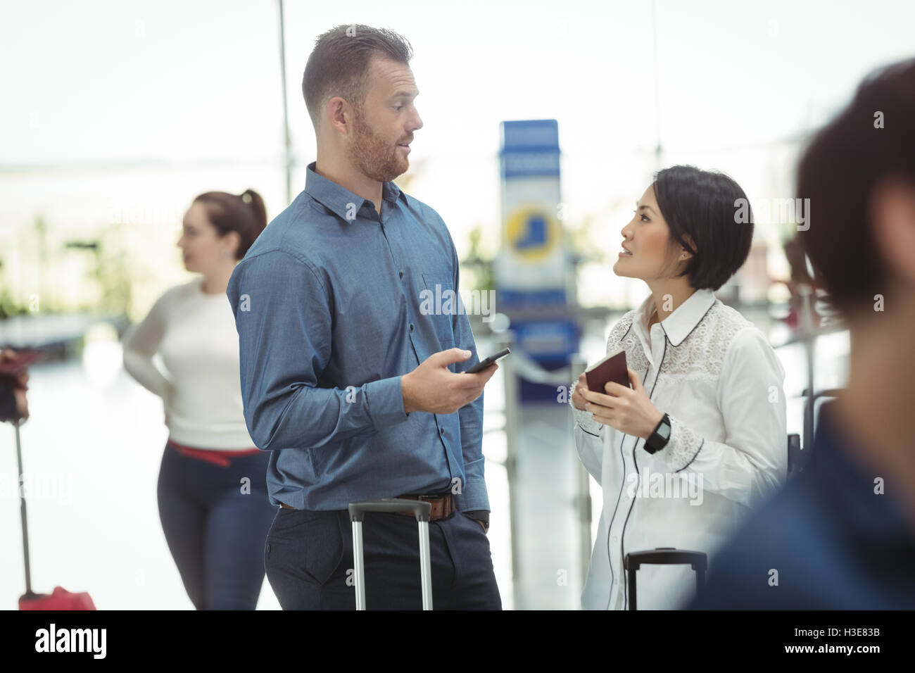Business people holding boarding pass and using mobile phone Stock Photo
