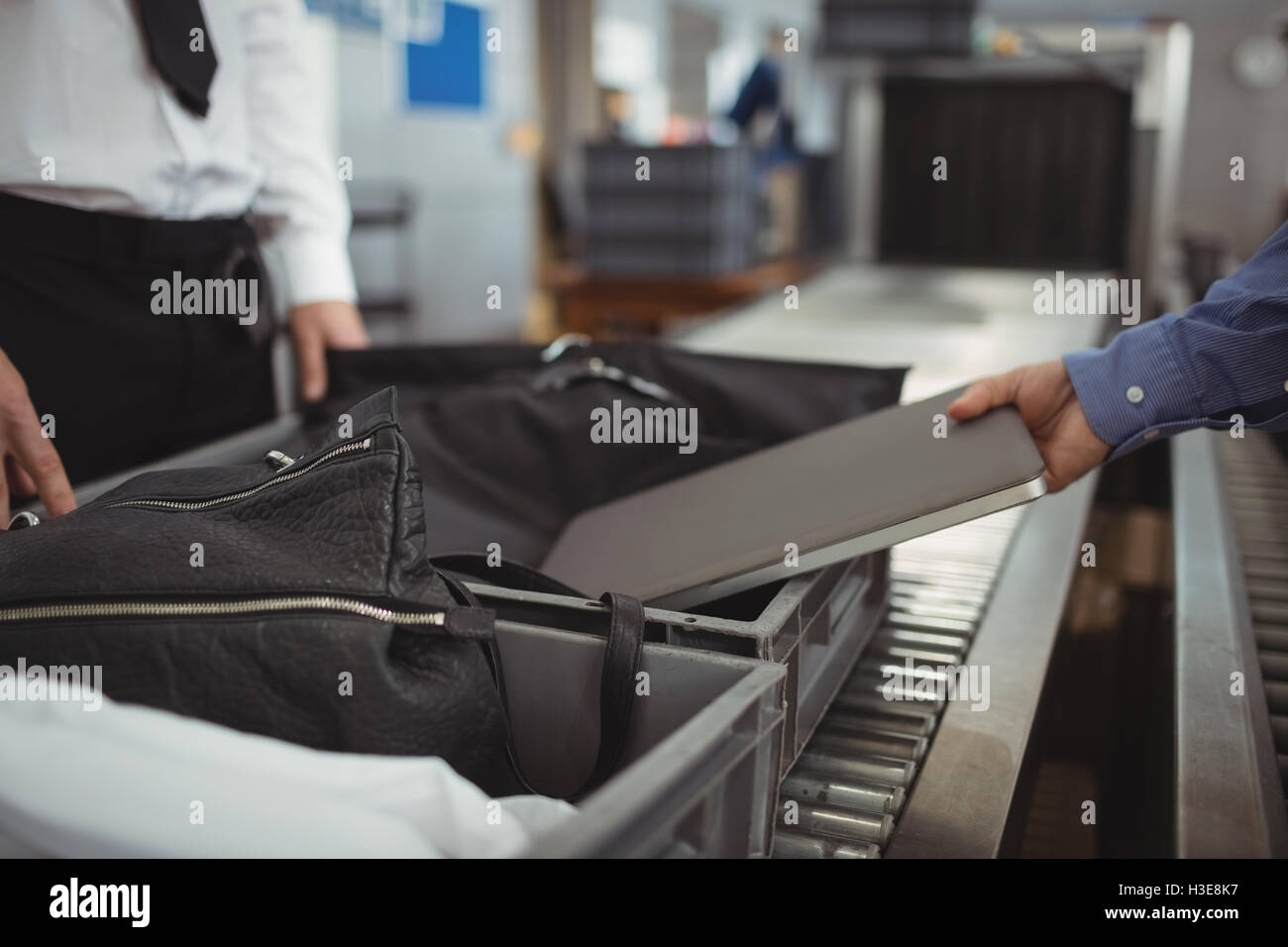 Man putting laptop into tray for security check Stock Photo