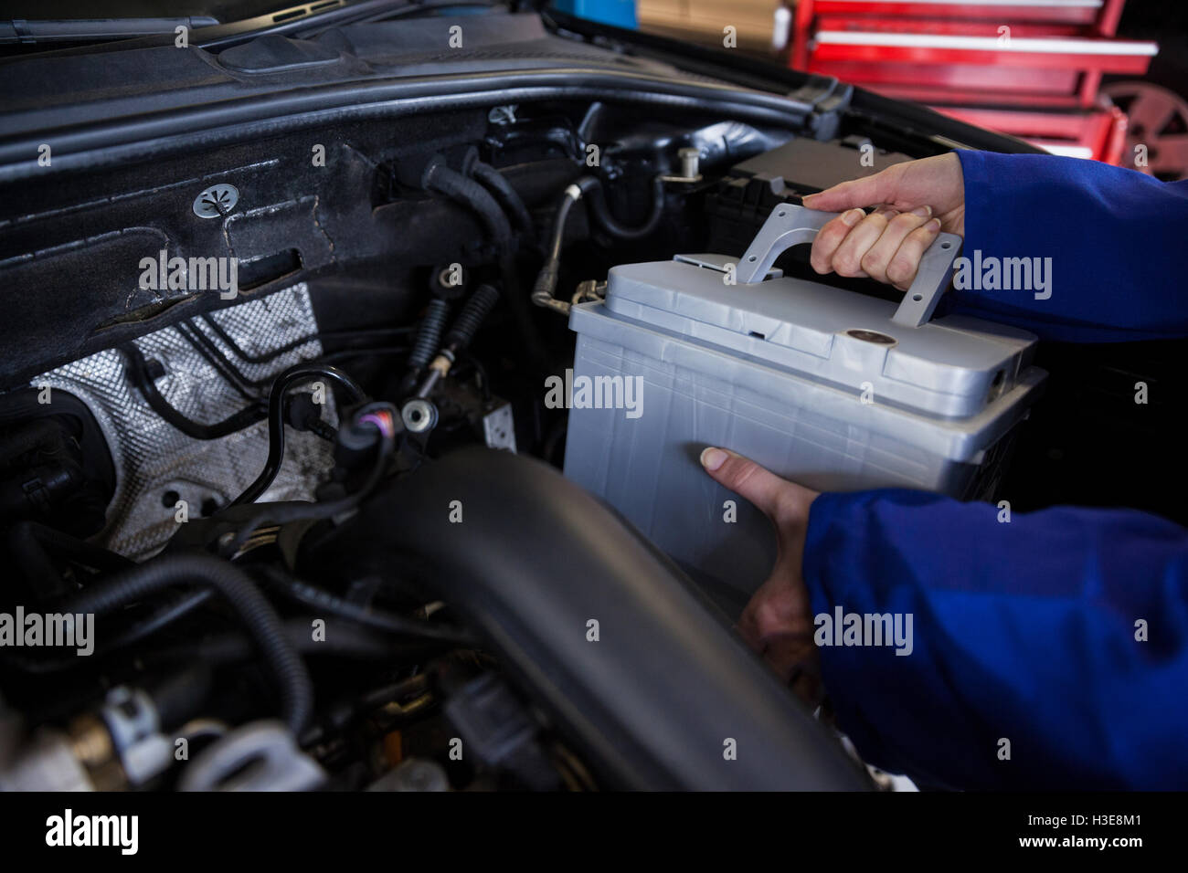 Mechanic removing car battery from car Stock Photo Alamy