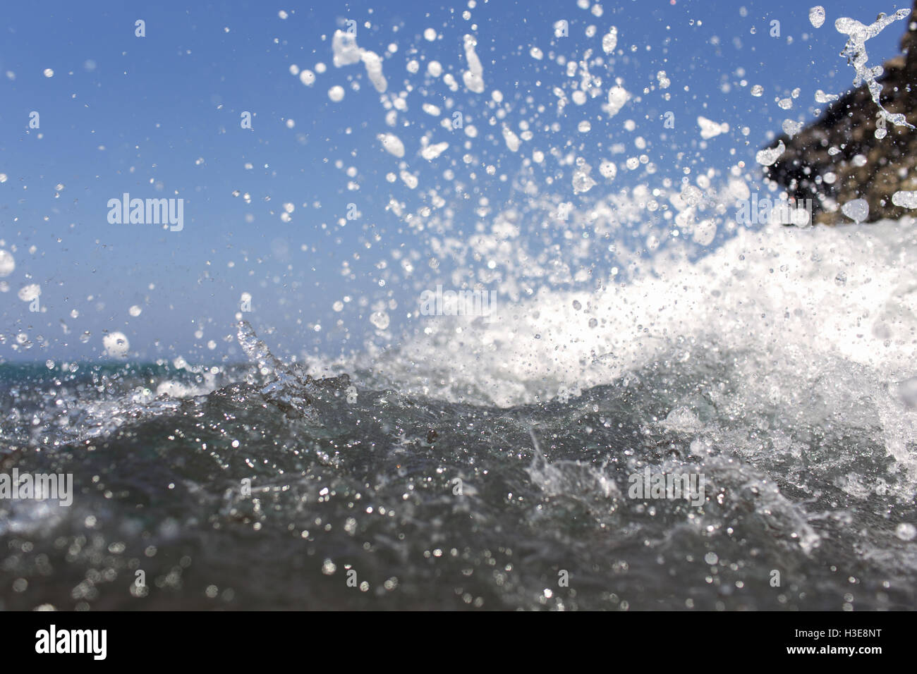 Sea wave splashing over the shore rocks with a high sea spray Stock ...