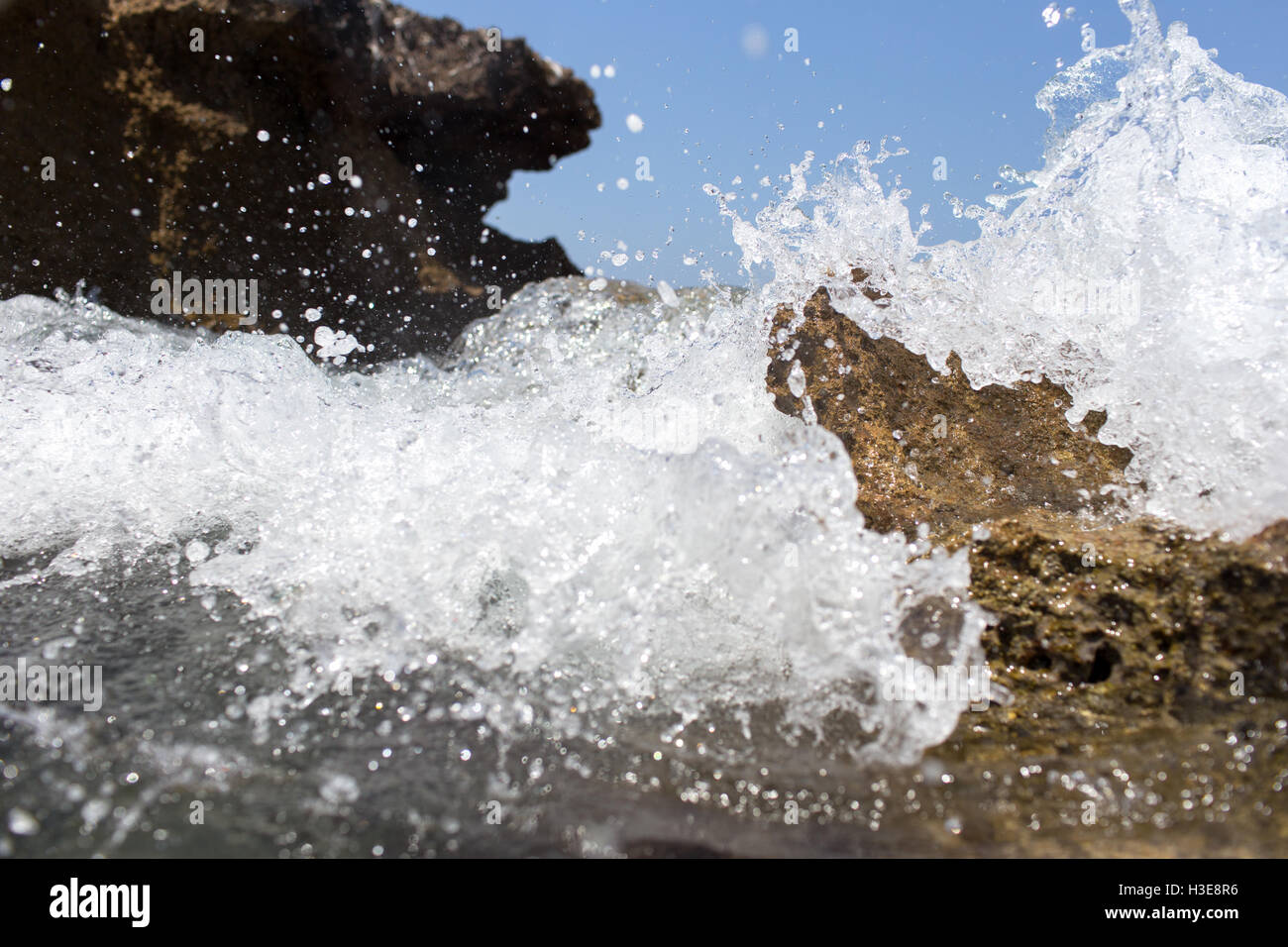 Sea wave splashing over the shore rocks with a high sea spray Stock ...