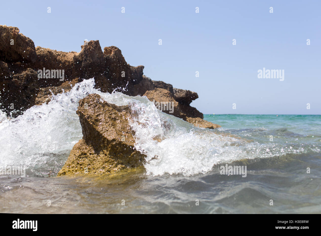 Sea wave splashing over the shore rocks with a high sea spray Stock ...