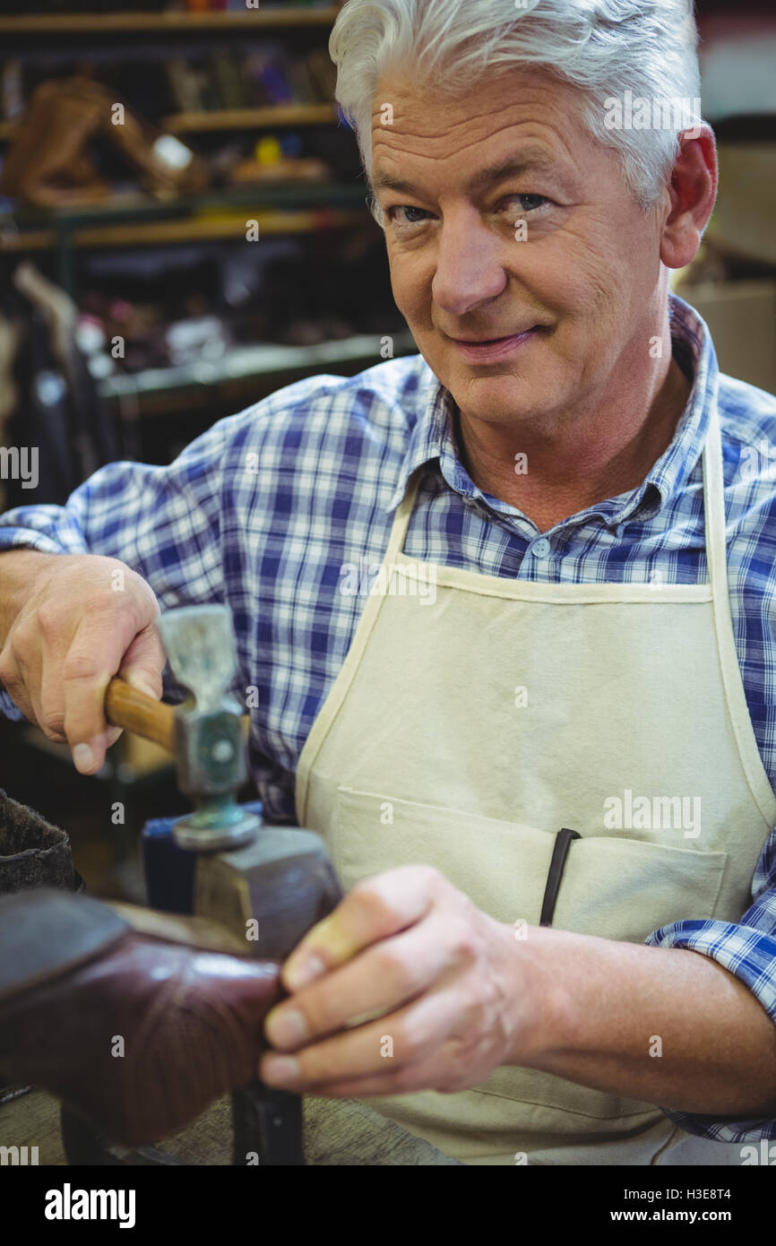 Portrait of shoemaker hammering on a shoe Stock Photo