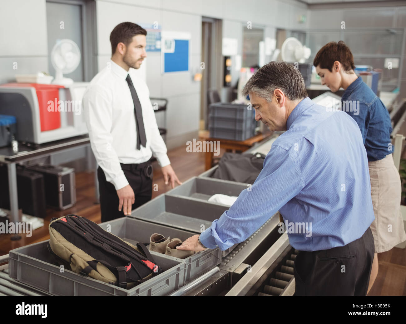 Man putting shoes into tray for security check Stock Photo