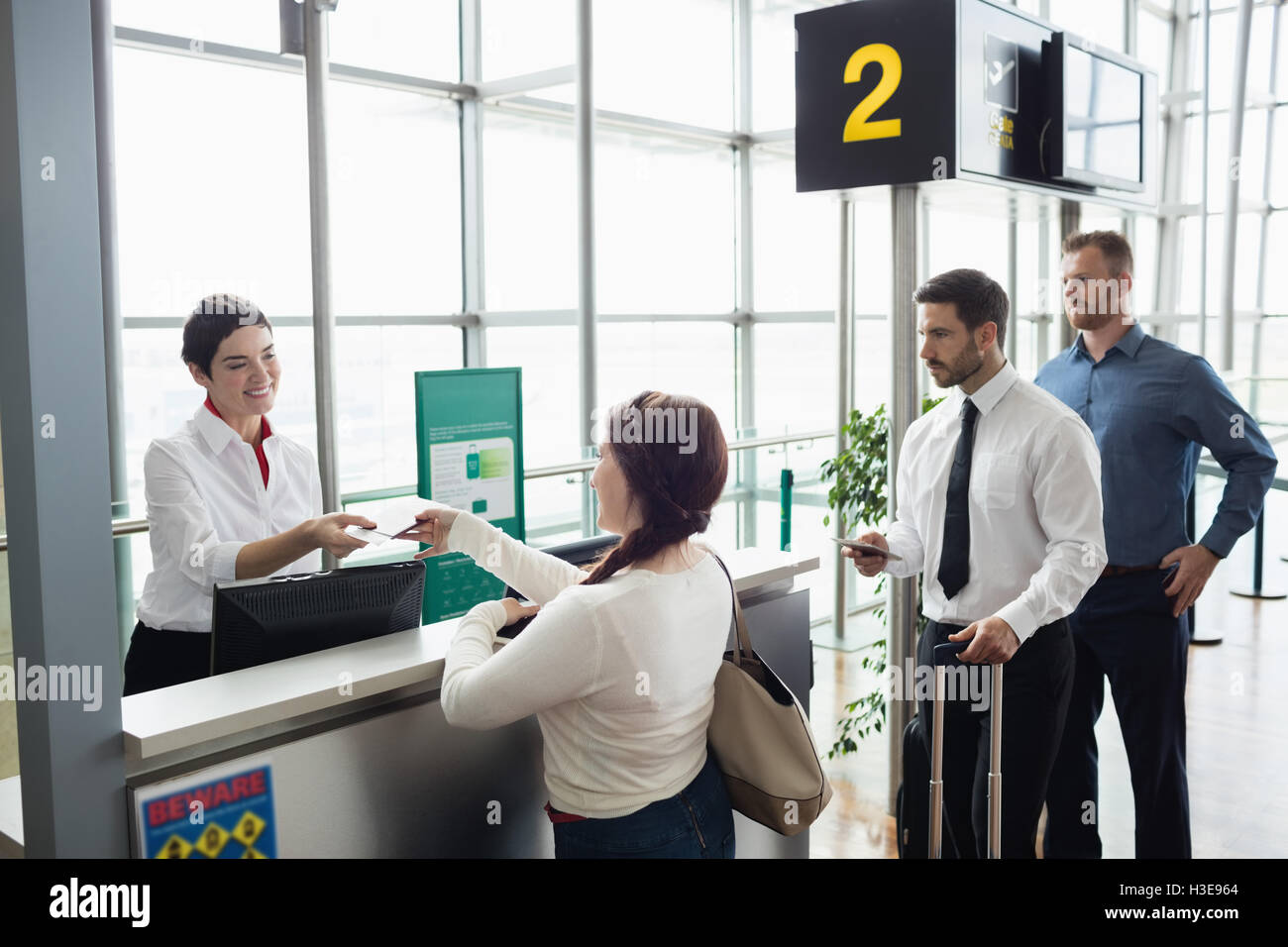 Woman giving her passport to airline check-in attendant Stock Photo