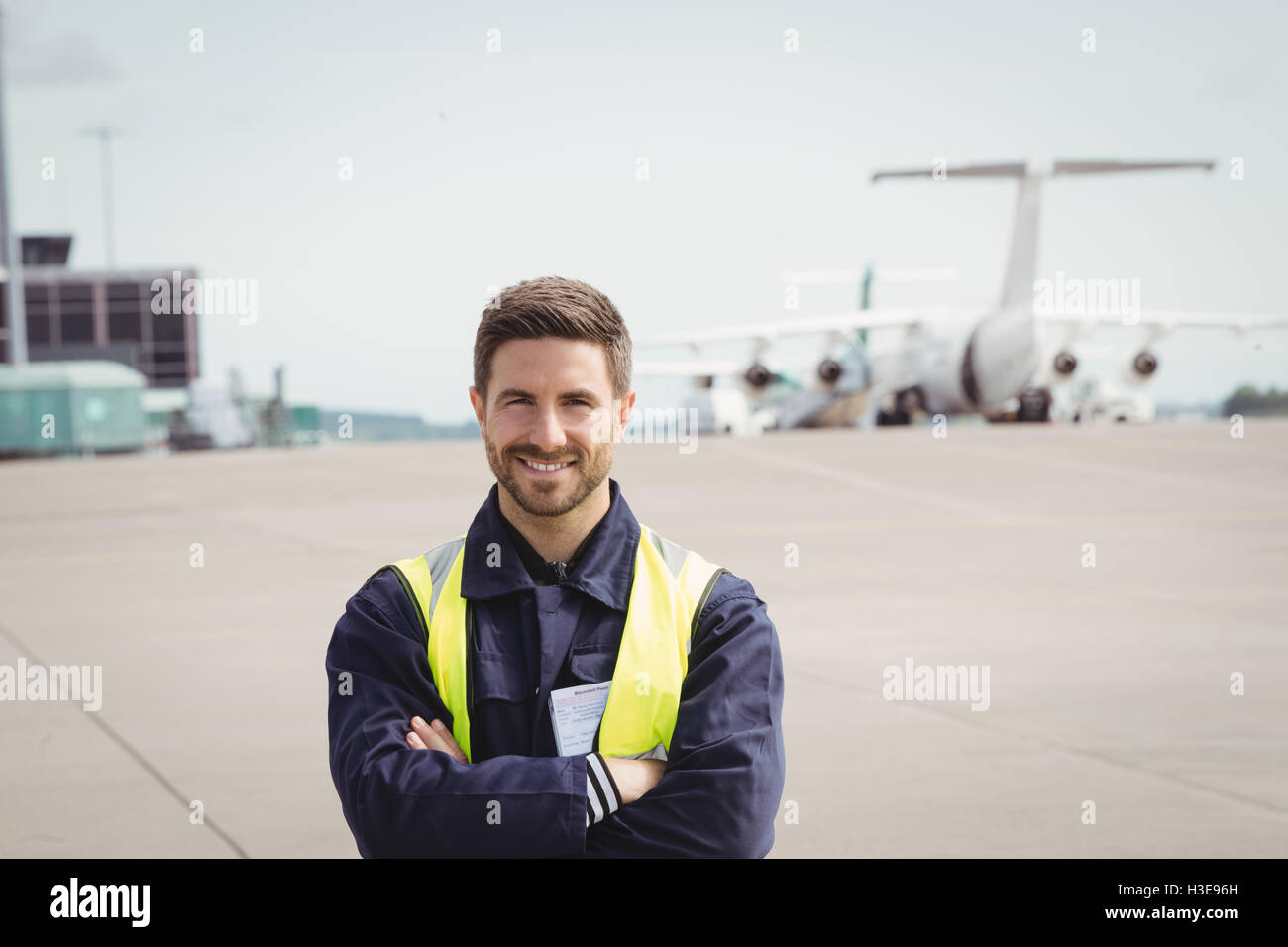 Portrait of airport ground crew standing with arms crossed Stock Photo