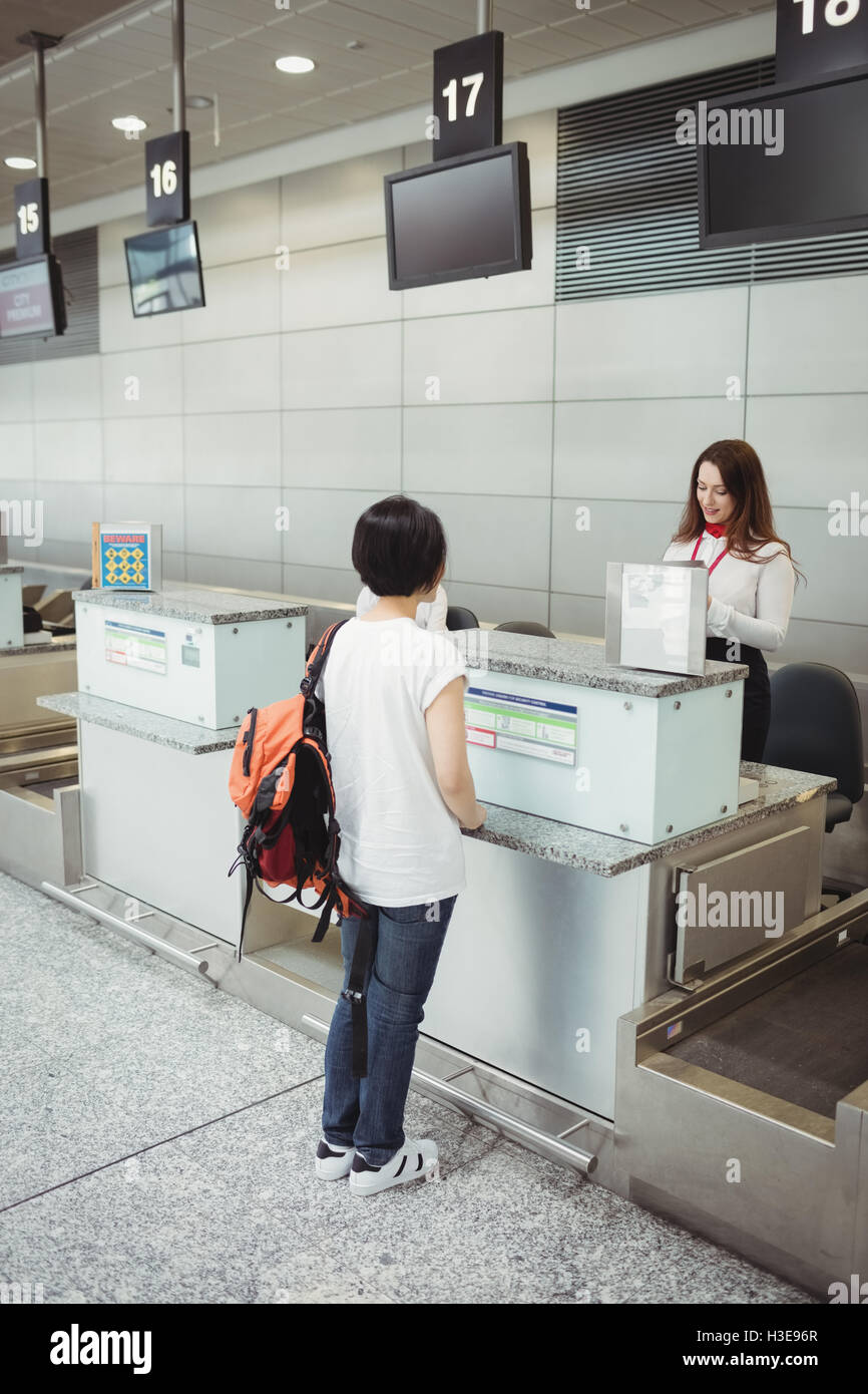 Airline check-in attendant checking passport of passenger Stock Photo