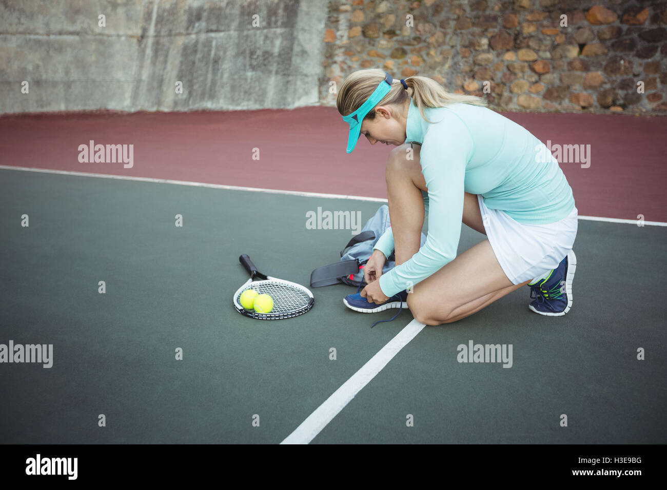 Female tennis player tying her shoe lace Stock Photo Alamy