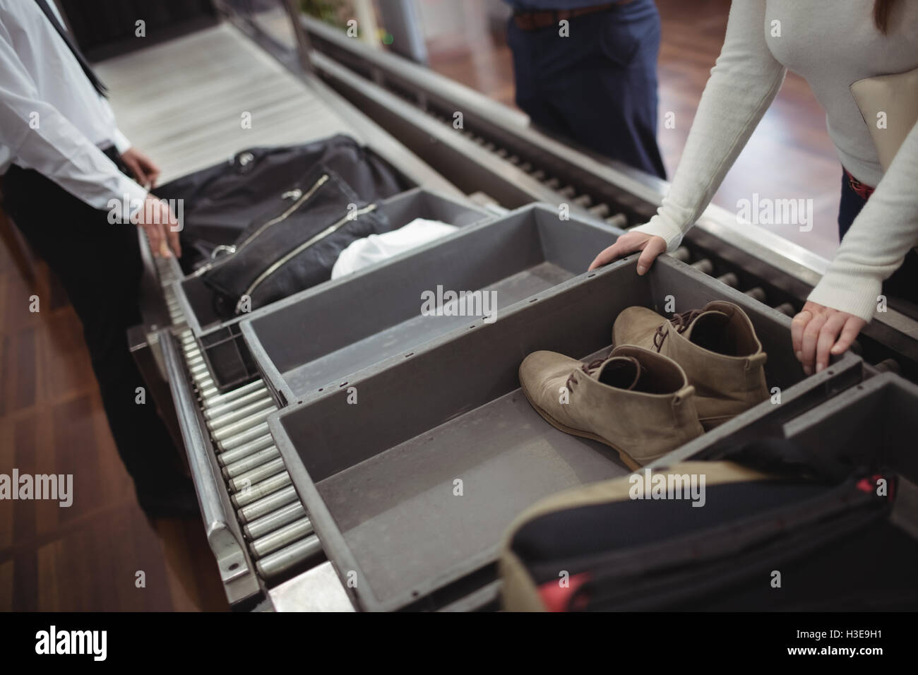 Woman putting shoes into tray for security check Stock Photo