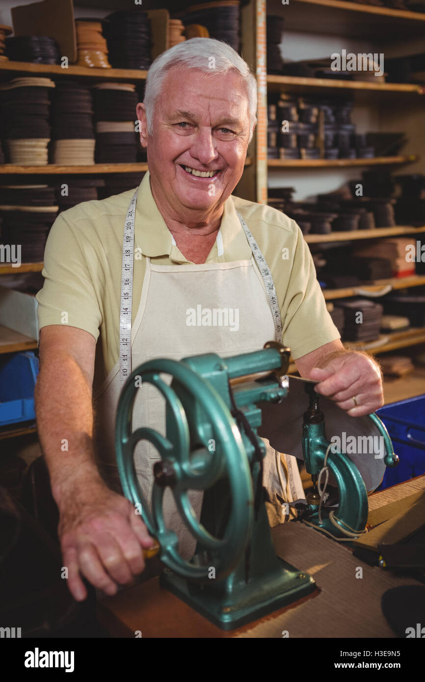 Portrait of shoemaker using sewing machine Stock Photo