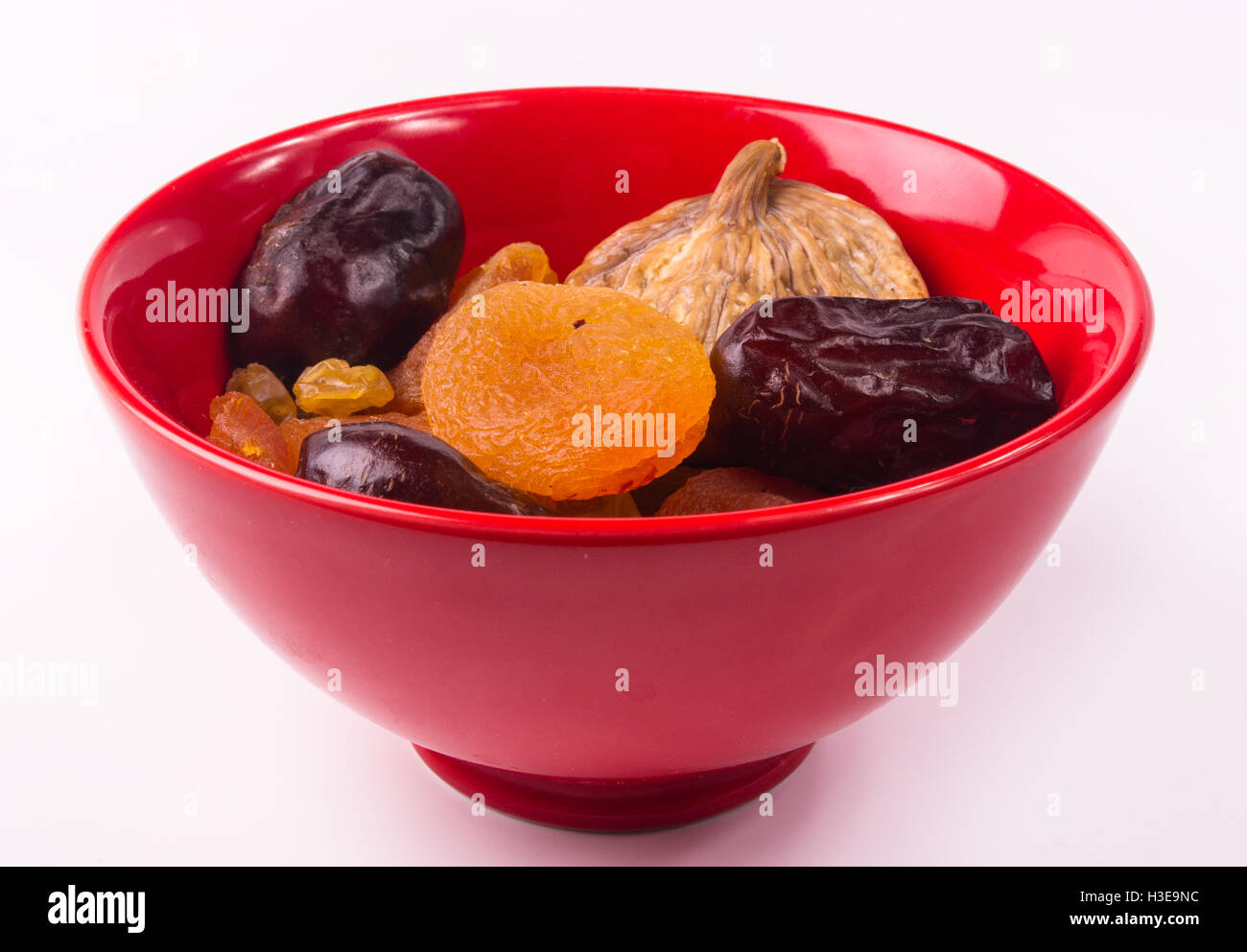various dried fruits in red plate on white background Stock Photo Alamy