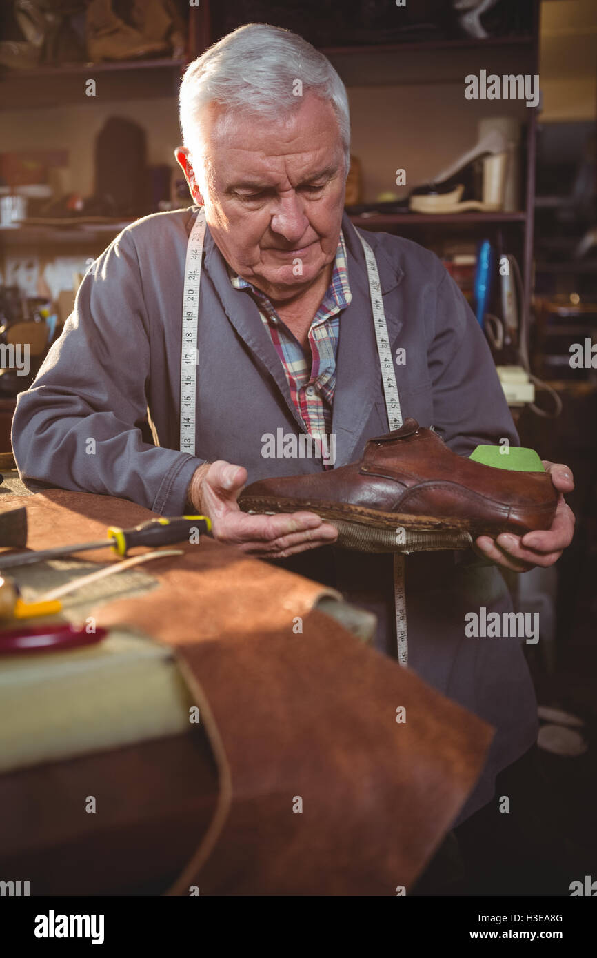 Shoemaker examining a shoe Stock Photo - Alamy