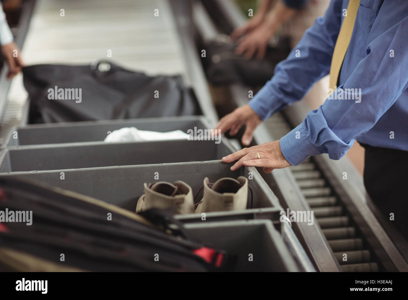 Man putting shoes into tray for security check Stock Photo