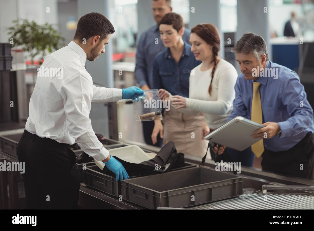 Commuter collecting their bags from the security counter Stock Photo