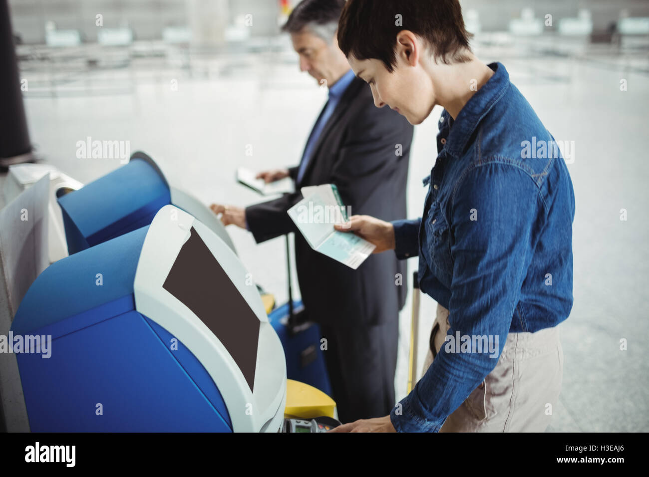 Business people using self service check-in machine Stock Photo