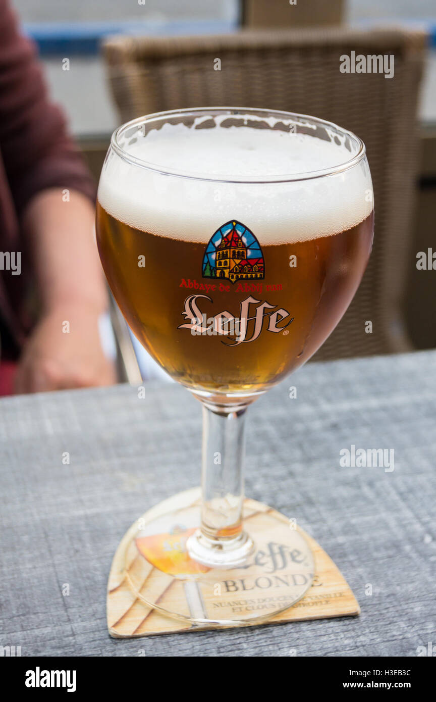 A printed glass of Leffe Blonde lager beer on a bar table, Bergues, Nord Pas de Calais, Hauts de France, France pub table drinks glasses Stock Photo