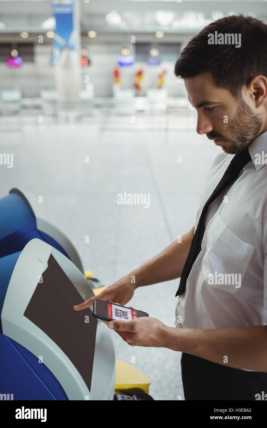 Traveller using self service check-in machine Stock Photo