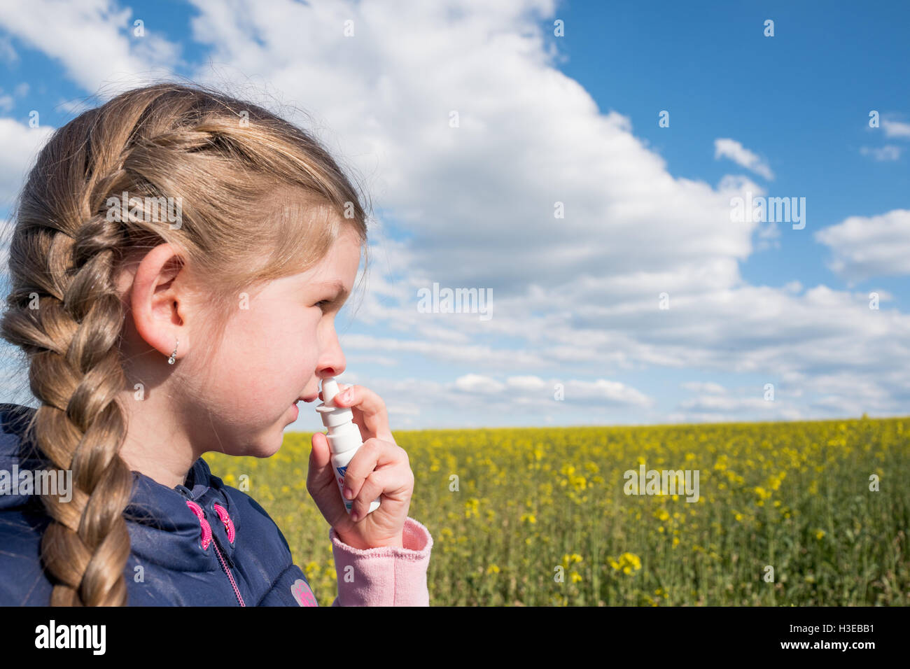 Beautiful young girl suffering from allergy using nasal spray Stock Photo